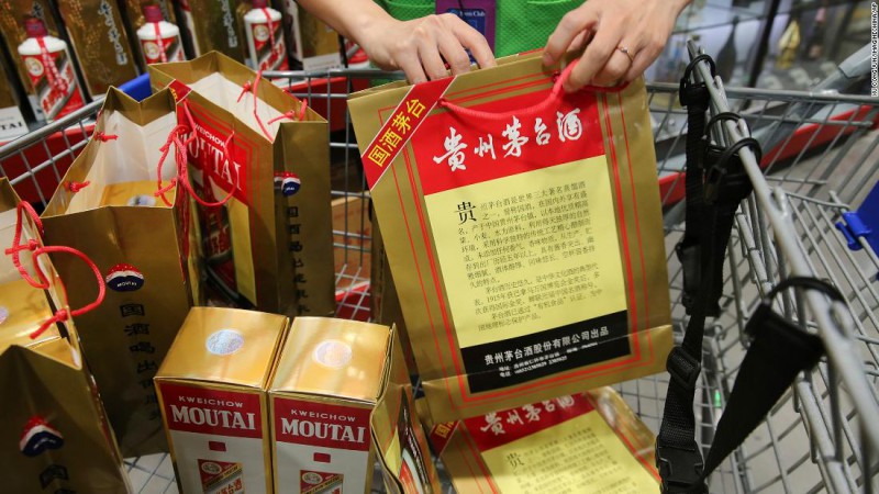 An employee displays China's leading liquor maker Kweichow Moutai at a supermarket in Nantong city, in China's Jiangsu province in 2018.